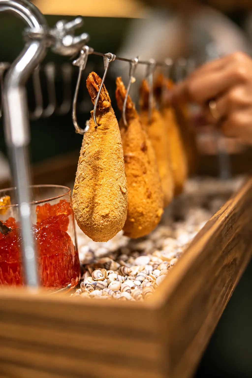 Signature croquettes suspended over shells with caviar service